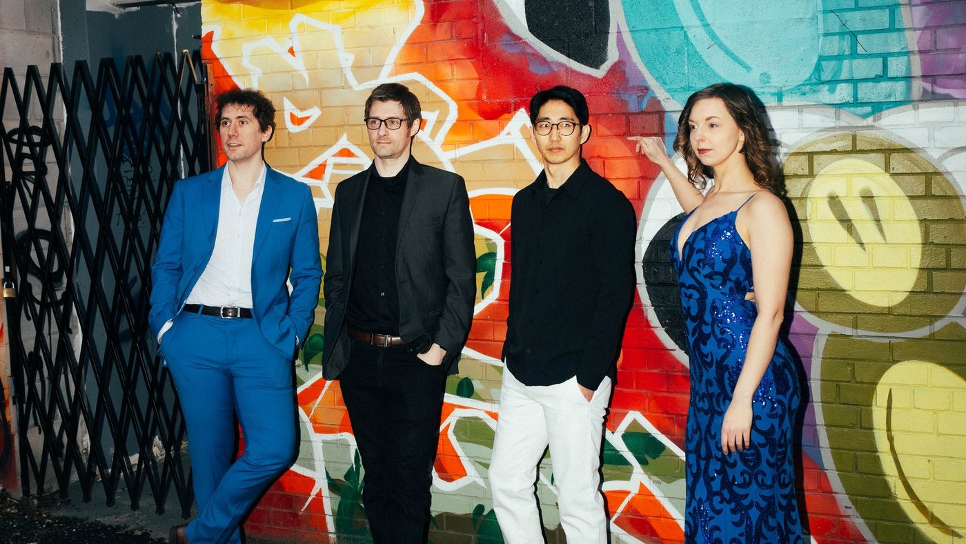 Awake & Dreaming standing in front of a painted mural: Stefan Schneider, Phil Lee, Ryan Dugal and Sasha Kristoff