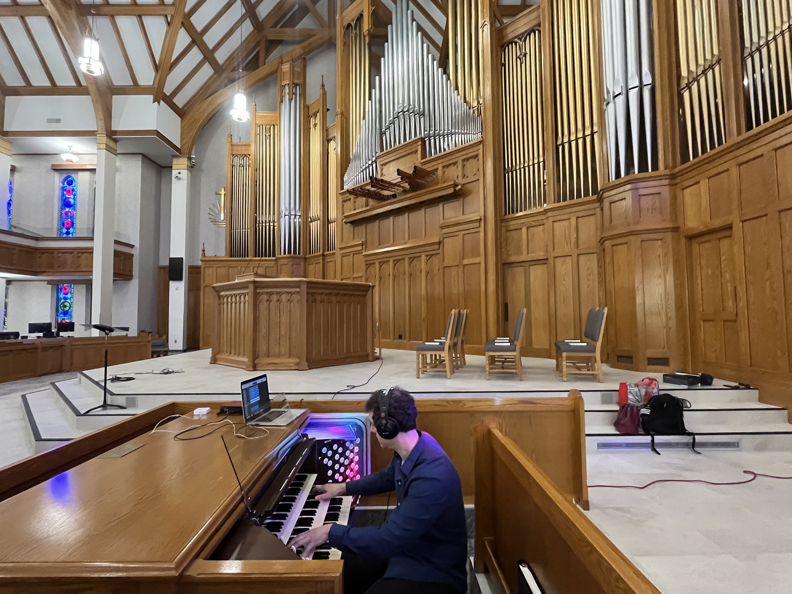 Stefan Schneider at the console of the pipe organ at New Apostolic Church in Kitchener, the pipes rising behind him